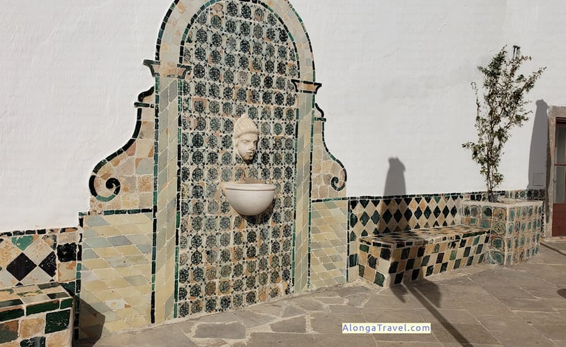 Exotic old round fountain on a wall with a face over it at Ala Joanina patio in Sintra National