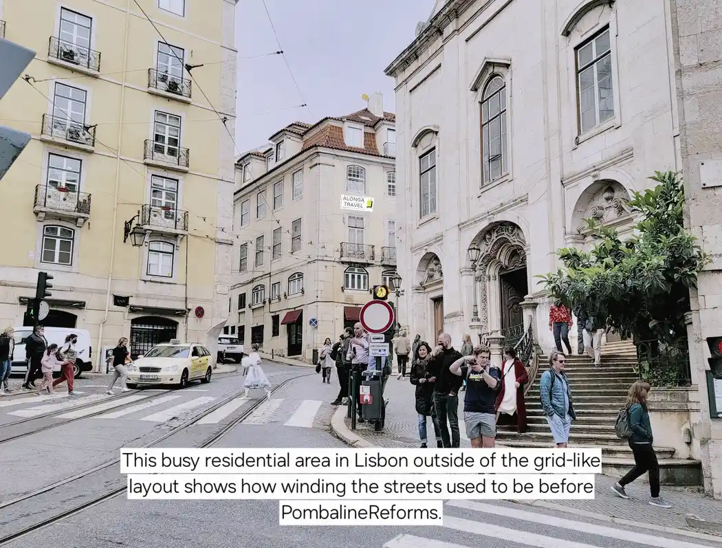 A busy curvy street in Lisbon center with people walking